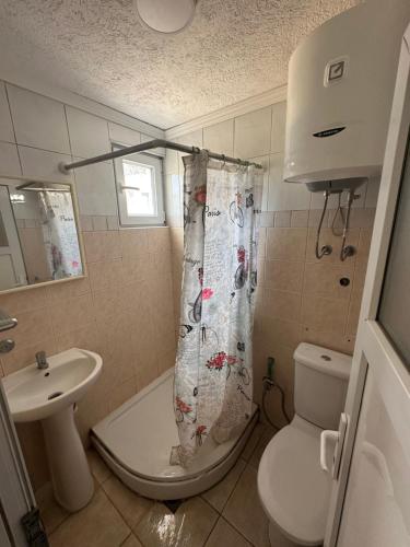 a bathroom with a toilet and a sink and a shower curtain at Apartmani Čavor in Budva