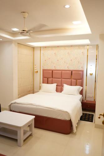 a bedroom with a large bed and a table at Hotel Maruti in Mandsaur