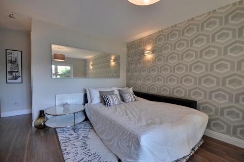 a bedroom with a large bed and a mirror at The Garden Apartment, Near Airport & City in Manchester