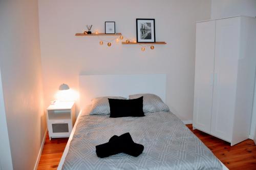 a bedroom with a bed with two black pillows on it at Dormir près de Brioude - studio 'esprit cocon' in Fontannes