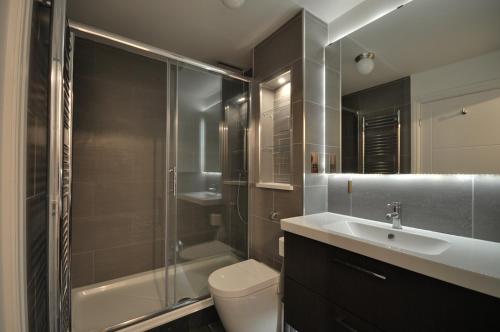 a bathroom with a toilet and a sink and a shower at The Garden Apartment, Near Airport & City in Manchester