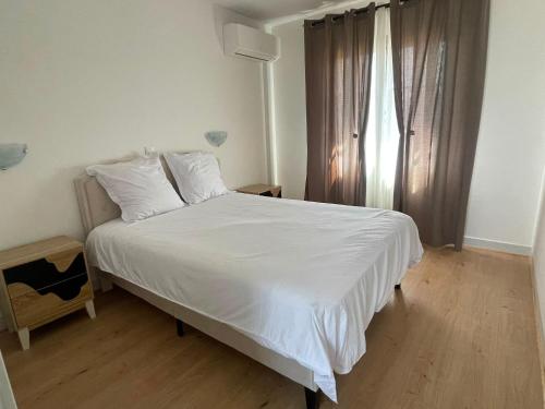 a bedroom with a white bed and a window at Barbe Bleue 1982 in Bridoré