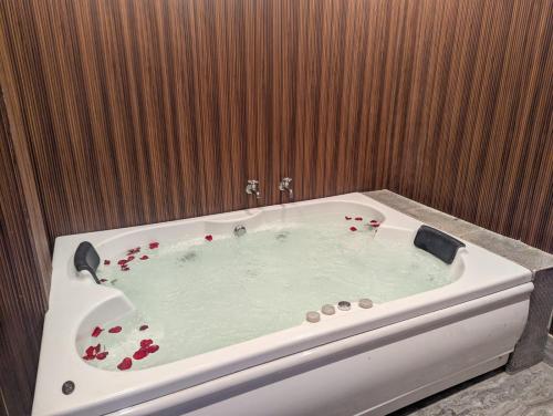 a bath tub with red flowers in it in a bathroom at Siliguri Club in Siliguri