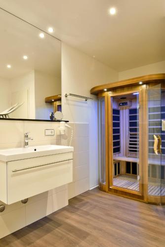 a bathroom with a sink and a glass door at Promenadenhotel Admiral in Bansin