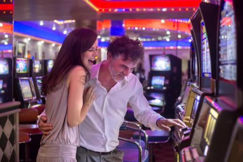 a man and a woman playing a video game in a casino at Majestic Mirage Punta Cana, All Suites – All Inclusive in Punta Cana