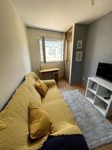a bedroom with a bed with yellow sheets and a television at Flat with nice view in Gualtar, Braga in Braga