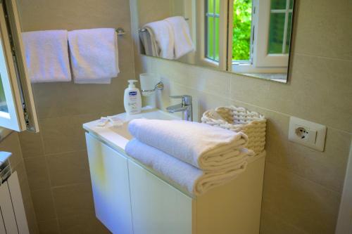 a bathroom with a sink and a mirror and towels at Villa dei Papi Subiaco in Subiaco