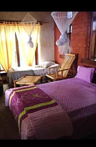 a bedroom with a bed and two beds with curtains at Jalé Ecolodge Acampamento in São Tomé