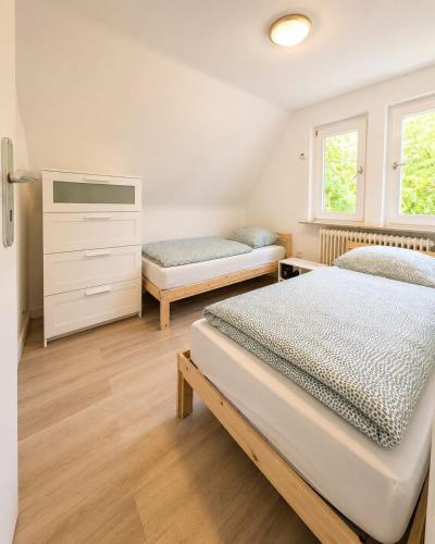 a bedroom with two beds and a dresser at Arkadia Monteur-Haus Seevetal in Seevetal