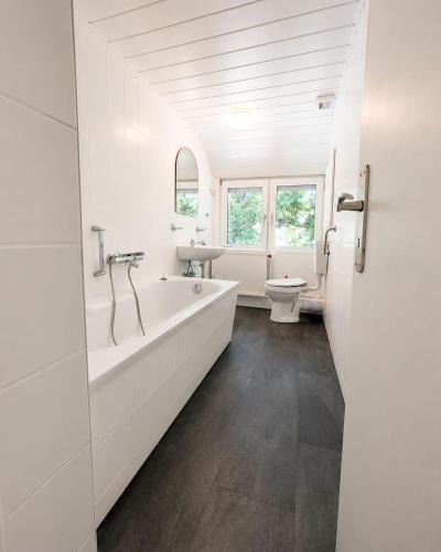 a white bathroom with a tub and a sink at Arkadia Monteur-Haus Seevetal in Seevetal