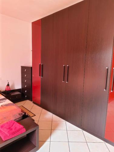 a bedroom with brown cabinets and a red wall at Apartment with three double bedrooms in Altavilla Vicentina