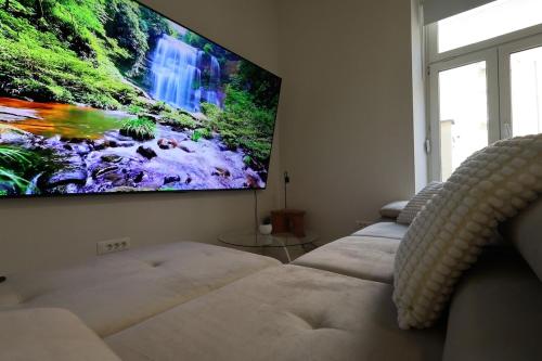 a living room with three couches and a flat screen tv at Downtown Condo w Huge TV in Zagreb