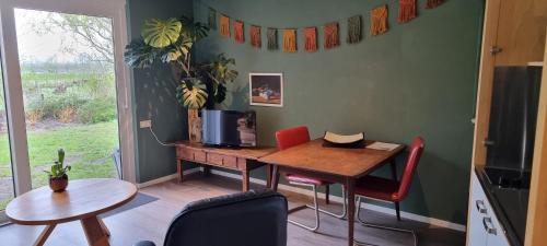 a dining room with a table and a table and chairs at B&B Even Heukelom - Kamer met Tuin in Afferden