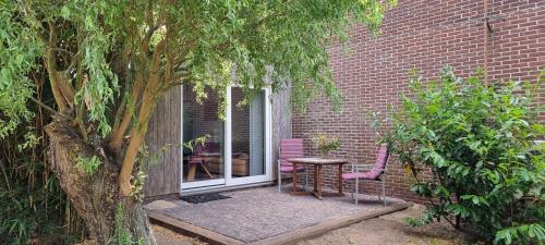 a patio with a table and chairs next to a brick building at B&B Even Heukelom - Kamer met Tuin in Afferden