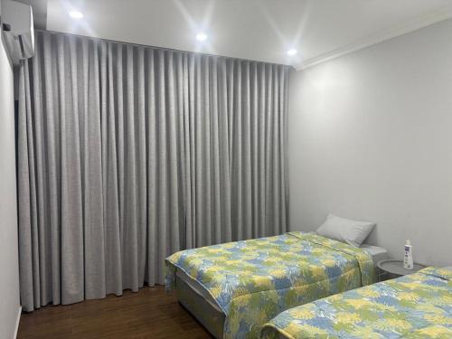 a bedroom with two beds and a window with curtains at Ponto de Ouro in Lopes