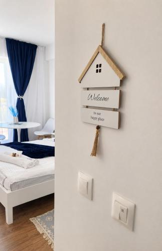 a bedroom with a bed and a sign on a wall at Zen Studio Olimp Poolside in Olimp