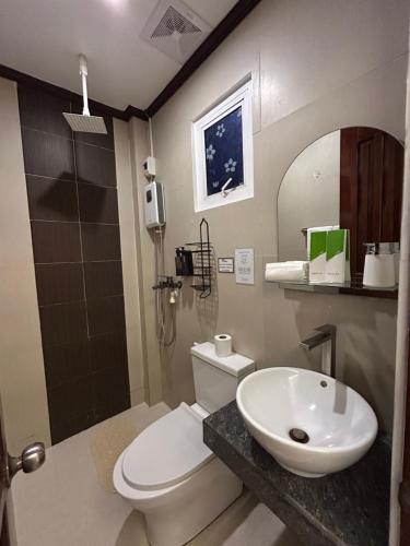 a bathroom with a toilet and a sink at Morocco Hotel El Nido in El Nido