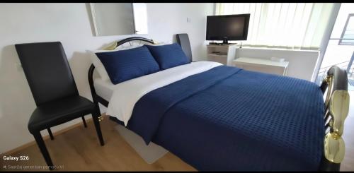 a bedroom with a blue bed and a chair at Sobe i apartmani "Terasa" in Smederevo