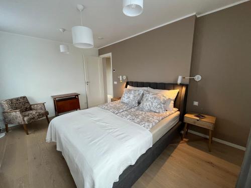 a bedroom with a large bed and a chair at Villa Eha in Kuressaare
