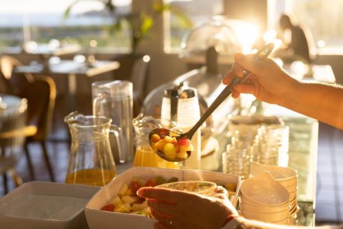 a person eating a bowl of food with a spoon at Hotel El Patio in Garachico