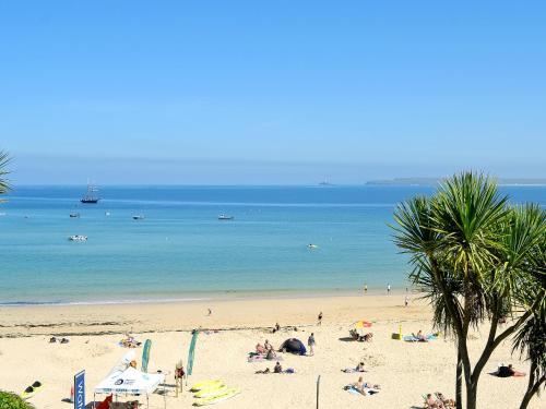 a group of people on a beach with the ocean at Driftwood in St Ives