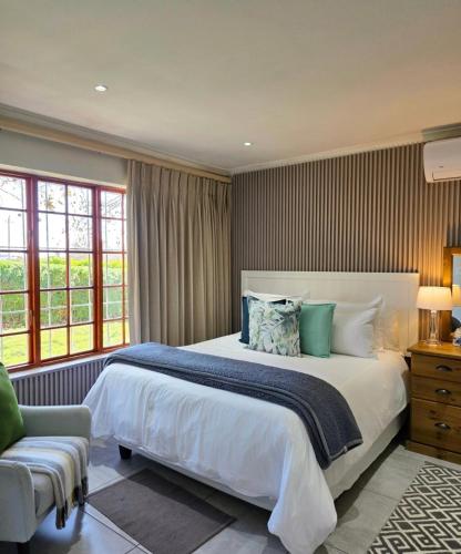 a bedroom with a large bed and a chair at Mon Rêve Estate in Cape Town
