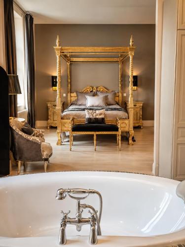 a bath tub in front of a bedroom with a bed at Château de Lavail in Labastide-dʼAnjou