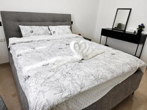 a bed with a white swan on top of it at הפינה של פנינה במושבה - דירה משפחתית מהממת in Migdal