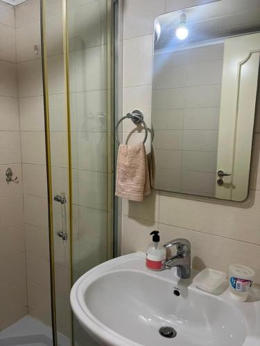 a bathroom with a sink and a shower with a mirror at Étoile Batroun in Batroûn