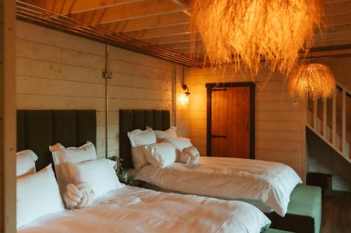 a bedroom with two beds and a chandelier at The Forest Loft in Drumsurn