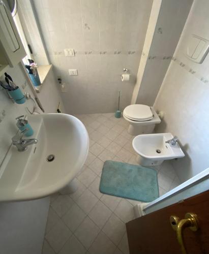 a white bathroom with a sink and a toilet at Gioia Casa in Pizzo