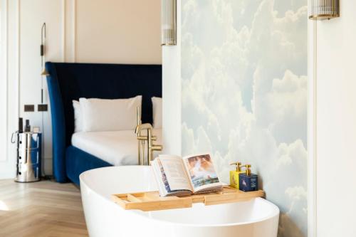 a bathtub with a book on it in a bedroom at Casa Laveni in Milan