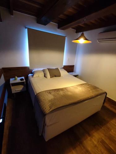 a bedroom with a large bed with a light on it at Pousada Ágape in Chapada dos Guimarães