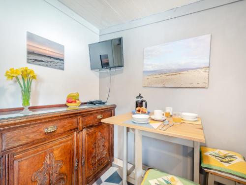 a kitchen with a table and a tv on the wall at Apostles Back House - Uk37313 in Lochranza