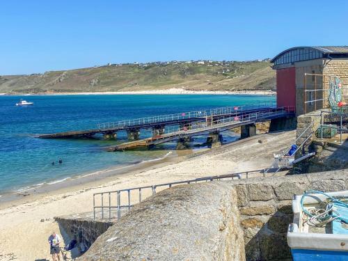 a beach with a pier with a train on it at The Lookout in Sennen