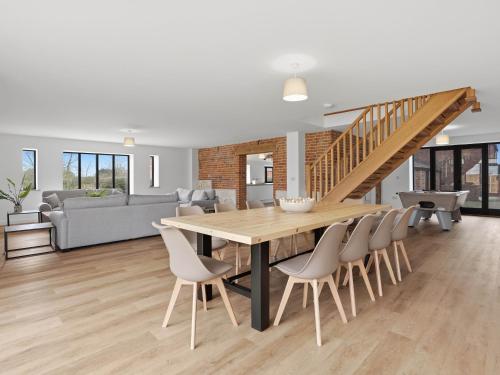 a dining room and living room with a table and chairs at Partridge Barn - Uk52217 in Corton