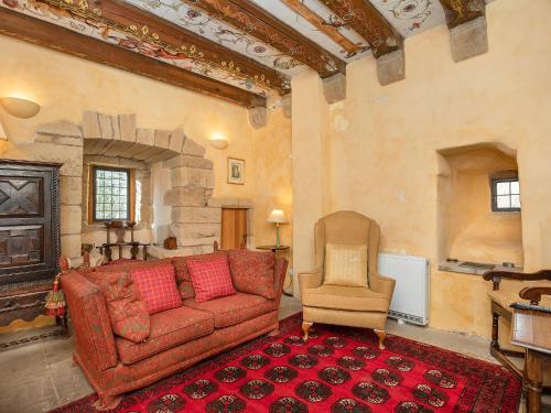 a living room with a red couch and a chair at Braidwood Castle - Uk10672 in Braidwood