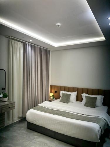 a bedroom with a large bed and a television at شقق كالم للشقق المخدومة 1 in Riyadh
