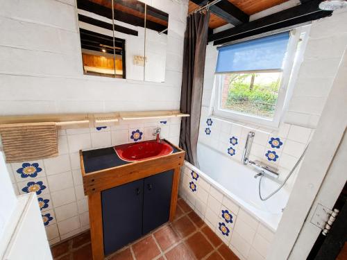 a bathroom with a red sink and a window at Havane13 in Hastière-par-delà