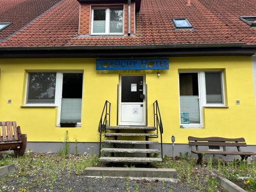 a yellow building with a sign that reads novent house at Vorsicht Hôtel in Deyelsdorf