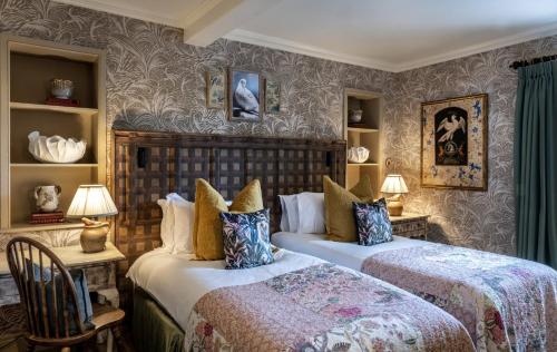 two beds in a room with wallpaper at The Loch Lomond Arms Hotel in Luss