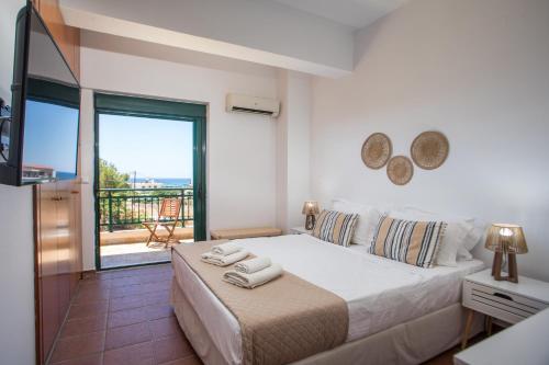 a bedroom with a large bed and a balcony at Villa Calliope Lardos in Lartos