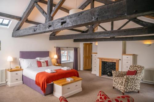 a bedroom with a large bed and a fireplace at Netherby Hall in Carlisle