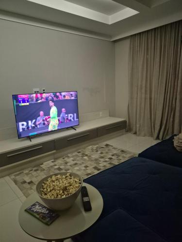 a living room with a bowl of popcorn and a tv at Treetops Home in Teresópolis