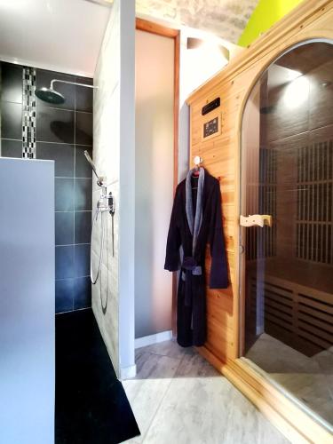 a bathroom with a robe hanging on a door at Gorge du Tarn Loft Cocoon Lesoleilo in Mostuéjouls