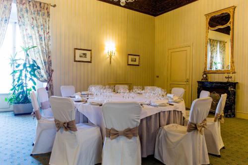a dining room with a table with white chairs and glasses at Palacio de los Velada in Avila
