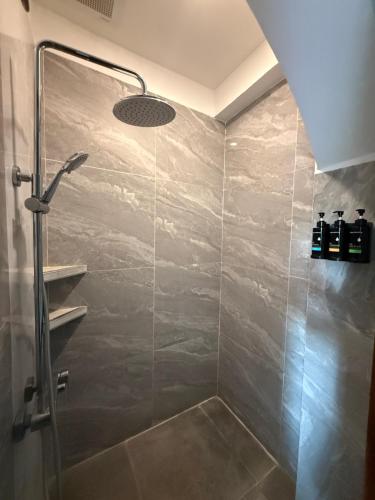 a bathroom with a shower with a glass door at Villa Virtud Beach Resort in Alegria