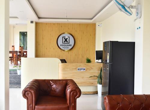 a living room with a leather chair and a table at Xsquare Hotel in Garubhāsa