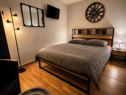 a bedroom with a bed and a clock on the wall at Le Parvis de PONT-AVEN in Pont-Aven