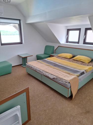 a bedroom with a bed and chairs in a attic at Amore Resort in Băltenii de Sus